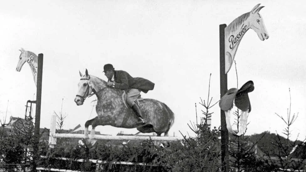 Springreiter auf einem Parcours mit Passier Hindernis